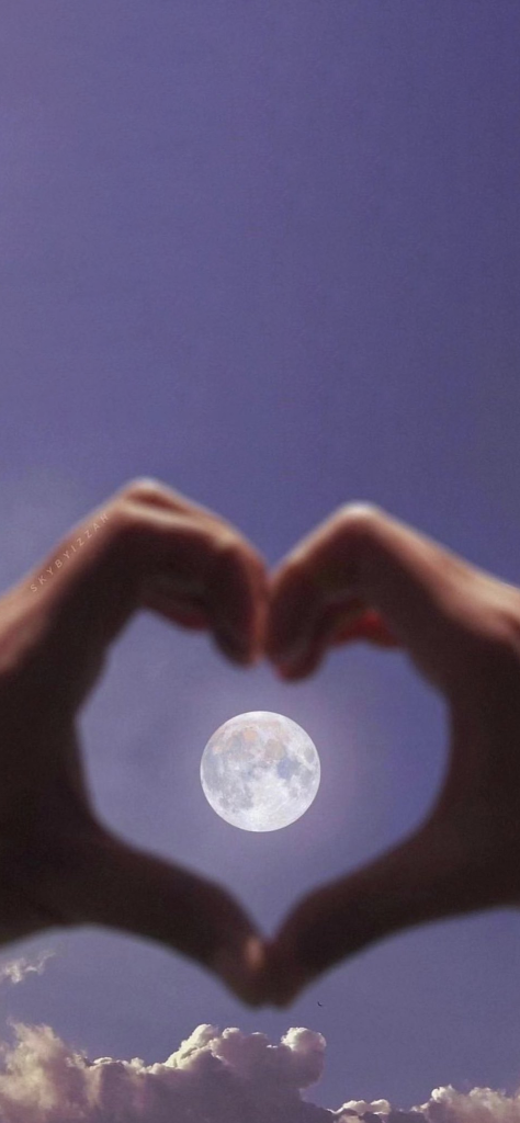 Fondo de pantalla de la luna con corazon hecho con las manos